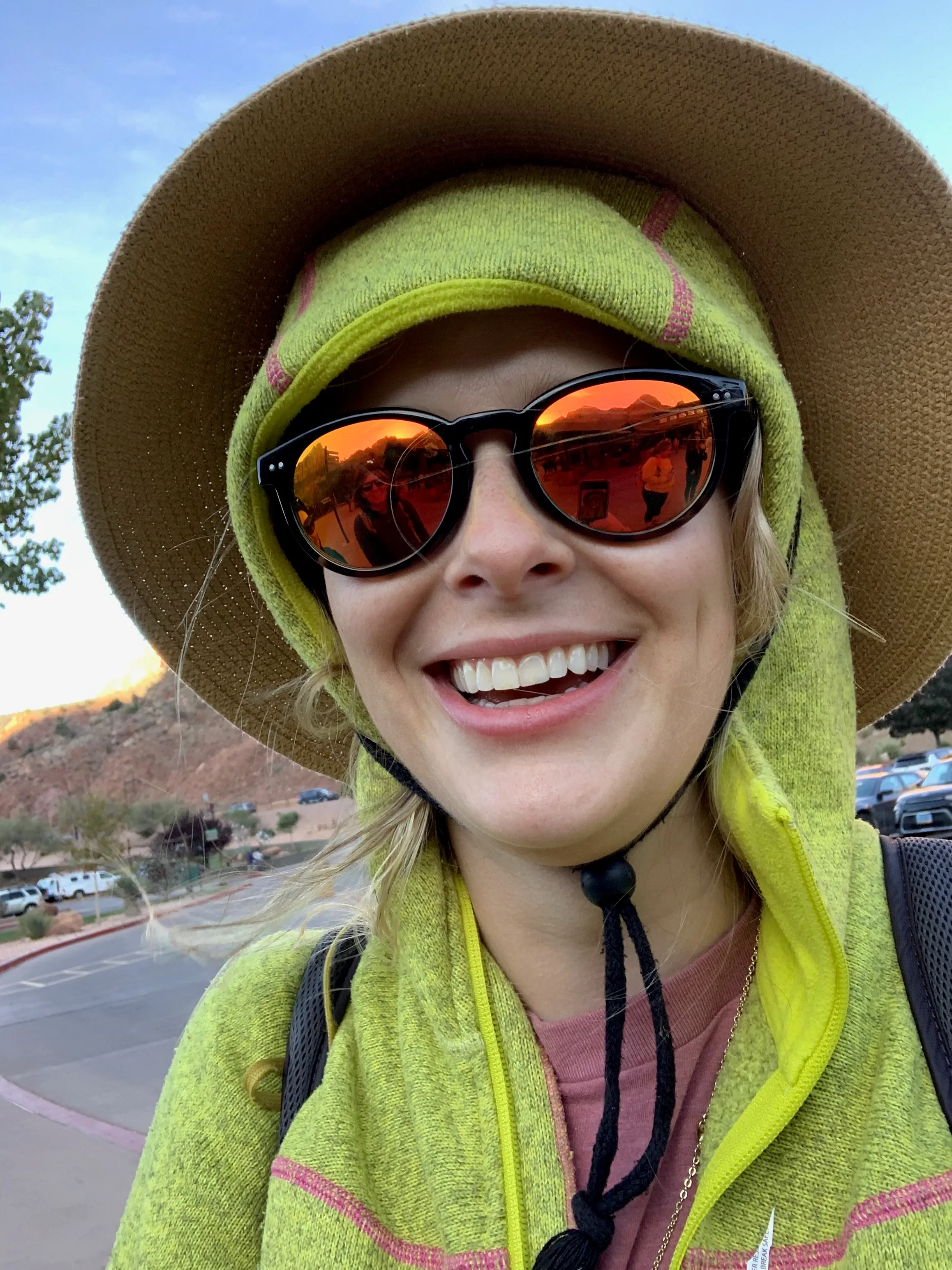 Kerianne Dyer, therapist, laughing in a sun hat and sunglasses outdoors
